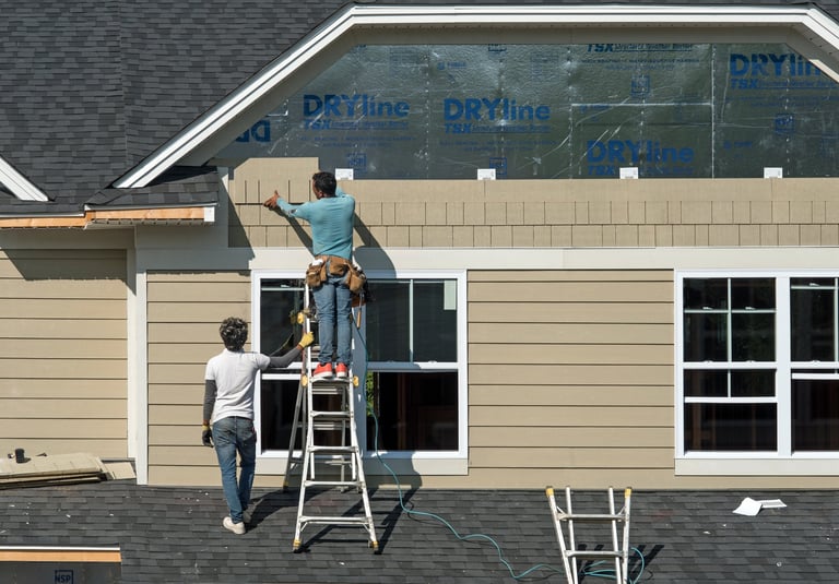 Construction workers installing siding