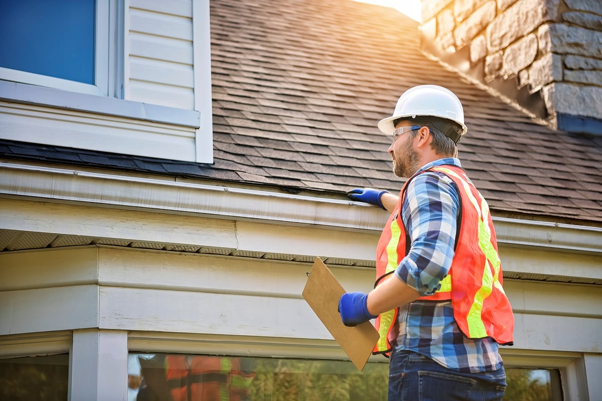 Professional contractor inspecting residential roof